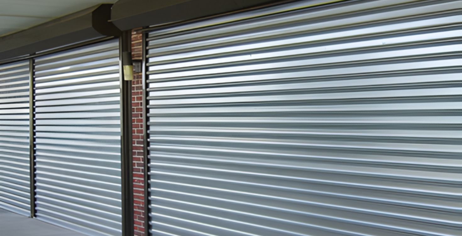 Porta de aço de enrolar sendo instalada em comércio